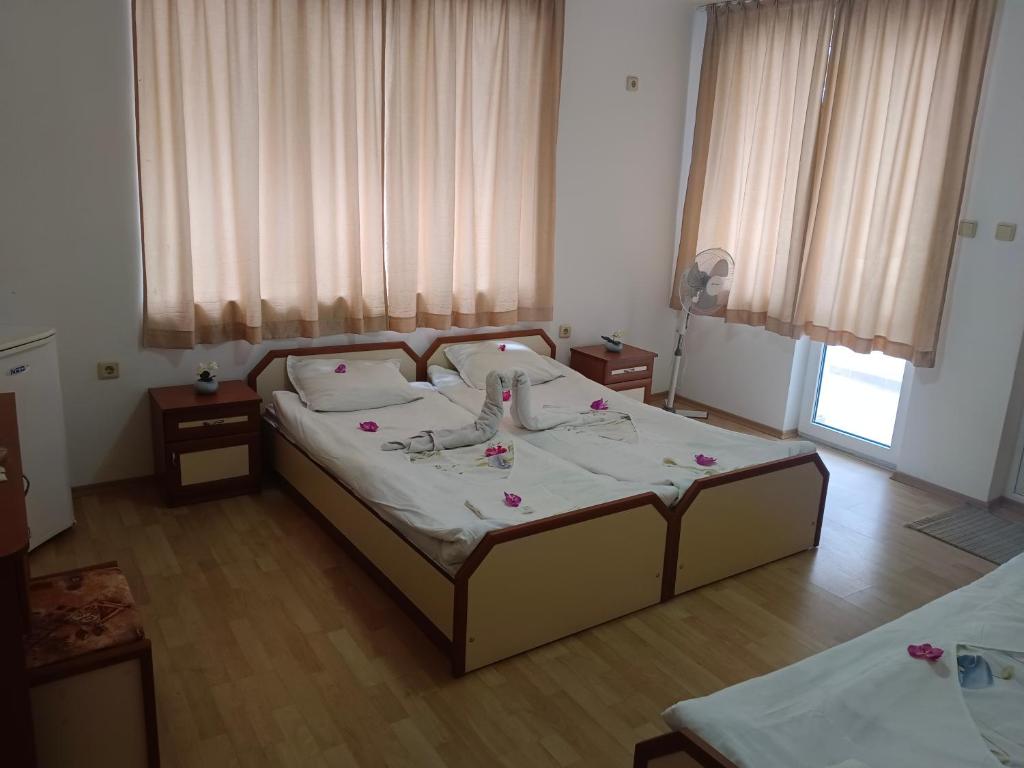 a bedroom with a bed with flowers on it at Стаи за гости Ники in Nesebar