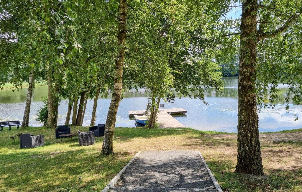 a dock with a bench and a boat on a lake at Awesome Apartment In Passow Ot Charlottenho With Wifi in Zahren