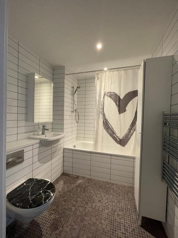 a bathroom with a heart drawn on the shower curtain at Perfect flat next to Wembley Stadium in London