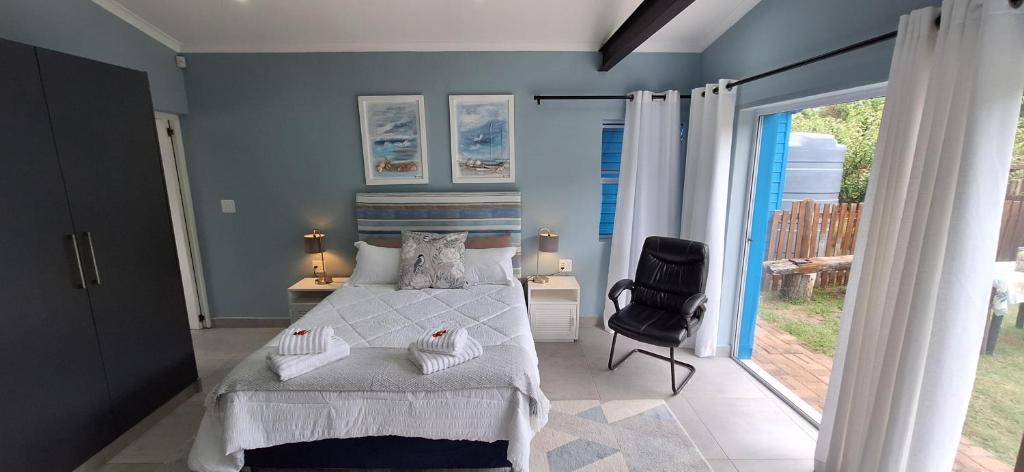 a bedroom with a bed and a chair and a window at Island Flip Flop Holidays in Sedgefield