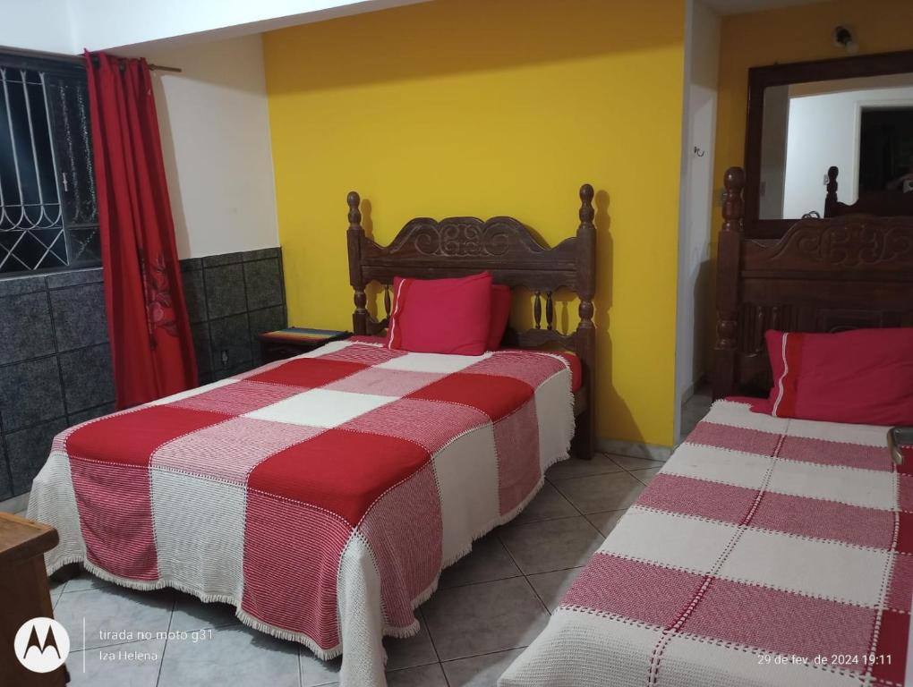 1 dormitorio con 2 camas con sábanas rojas y blancas en Raio de Sol en São João del Rei
