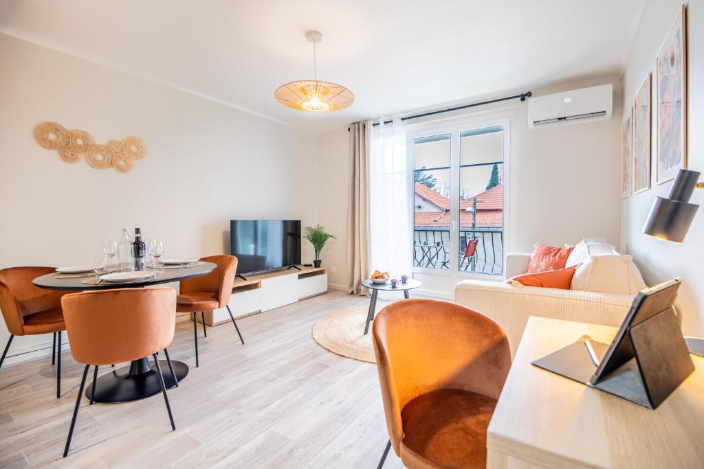 un salon avec une table et un canapé dans l'établissement Au calme de L'Iris - Clim - Garage - Wifi - Tramway, à Avignon