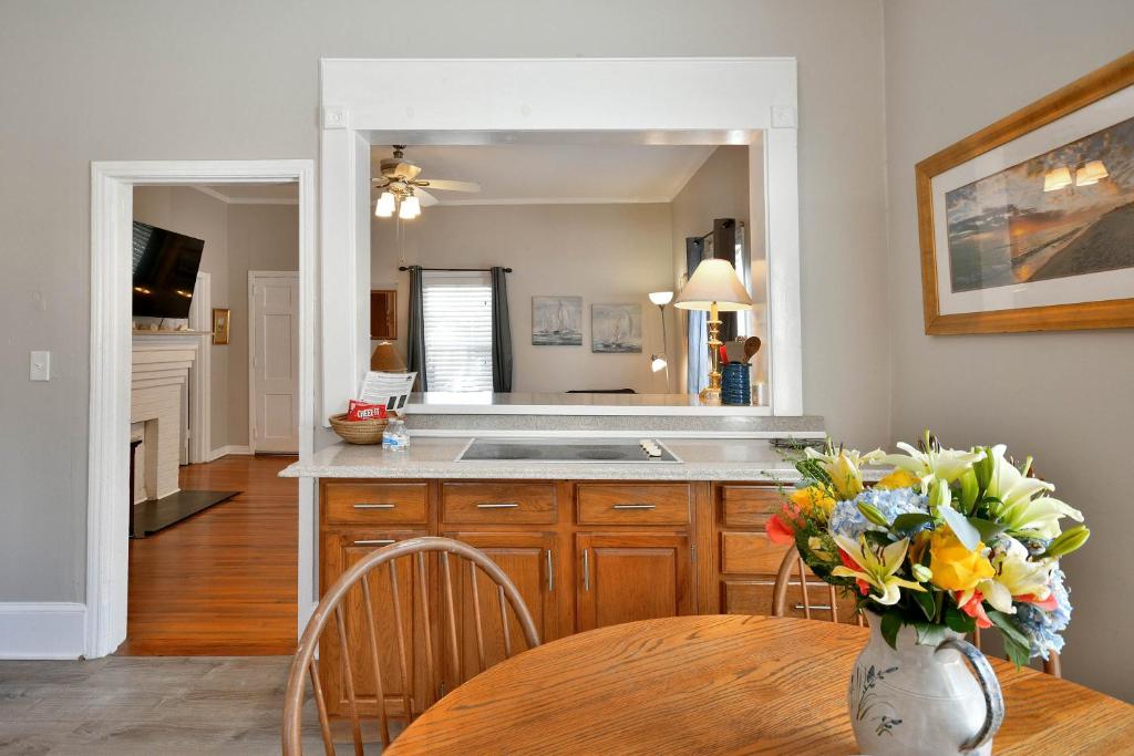 une cuisine avec une table et un vase de fleurs dans l'établissement Comfy Cottage: Minutes from Main St, Private Yard, à Greenville