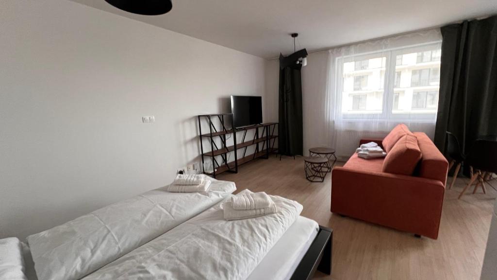 a bedroom with a bed and a chair and a window at 2 room Apartment with terrace, new building, B1 in Bratislava