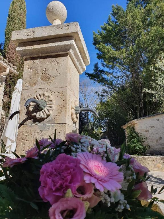 a stone monument with a bouquet of flowers at Le Mas des Aires - Chambres d&#39;Hôtes - Blauzac -Uzès - Pont du Gard in Blauzac
