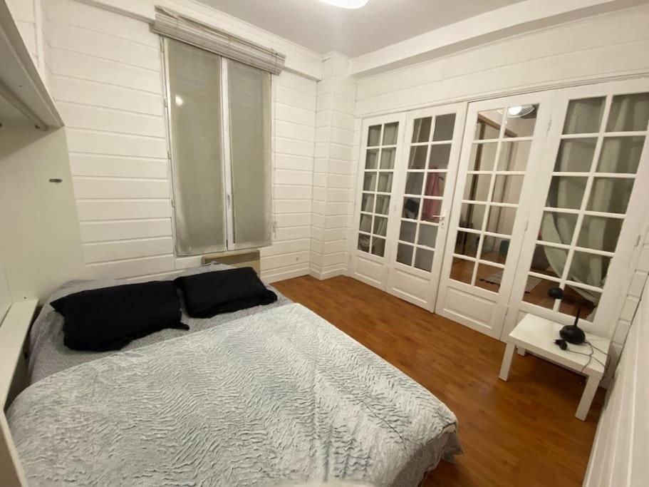 Una habitación blanca con una cama y una ventana en Appartement Design Champ de Mars, 2 piéces Quartier Tour Eiffel, en París