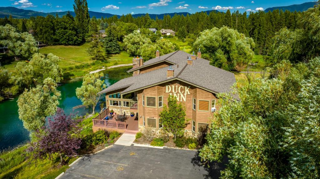 an aerial view of a large house with a lake at Duck Inn Lodge in Whitefish