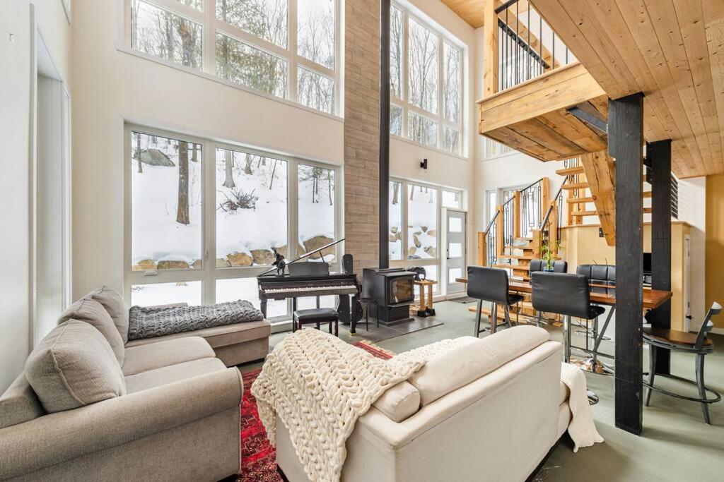 a living room with a couch and a piano at Cozy and beautiful chalet in Harrington