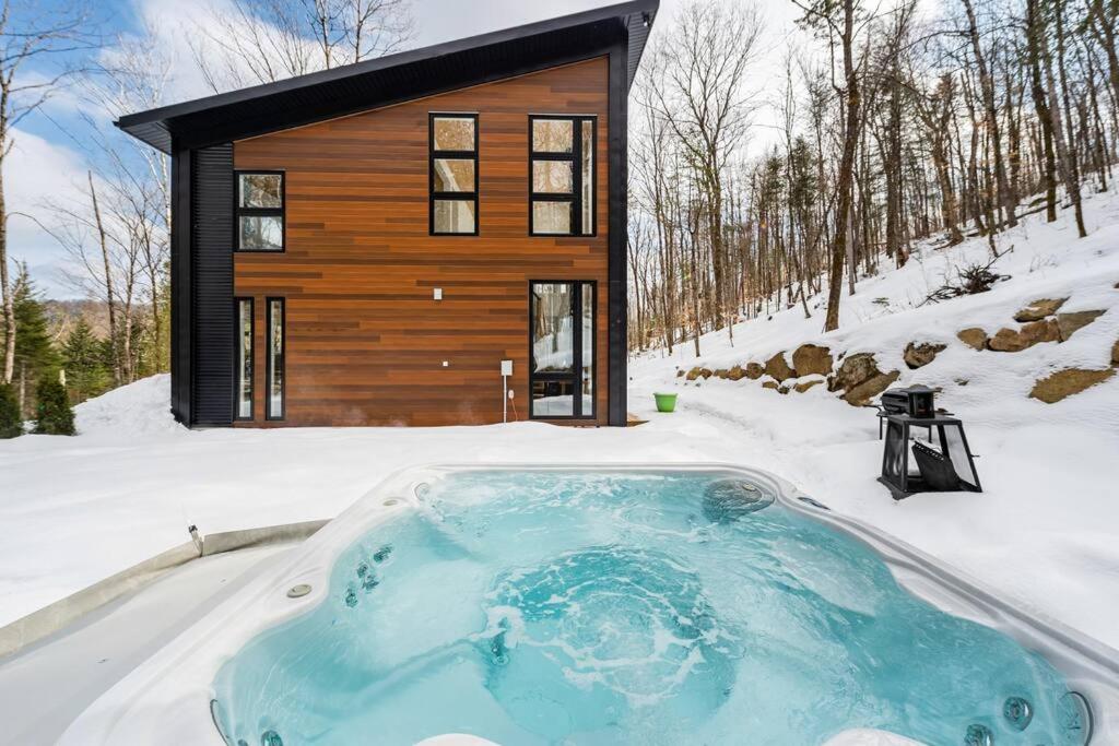 a house in the snow with a hot tub at Cozy and beautiful chalet in Harrington