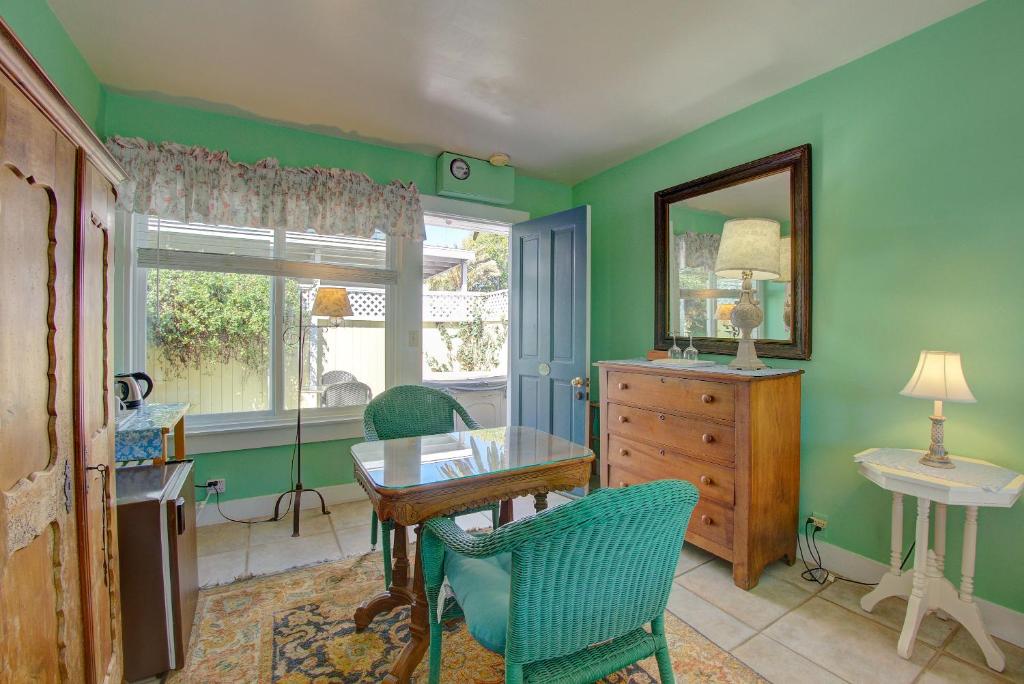 comedor con paredes verdes, mesa y sillas en Secret Garden Inn & Cottages en Santa Bárbara