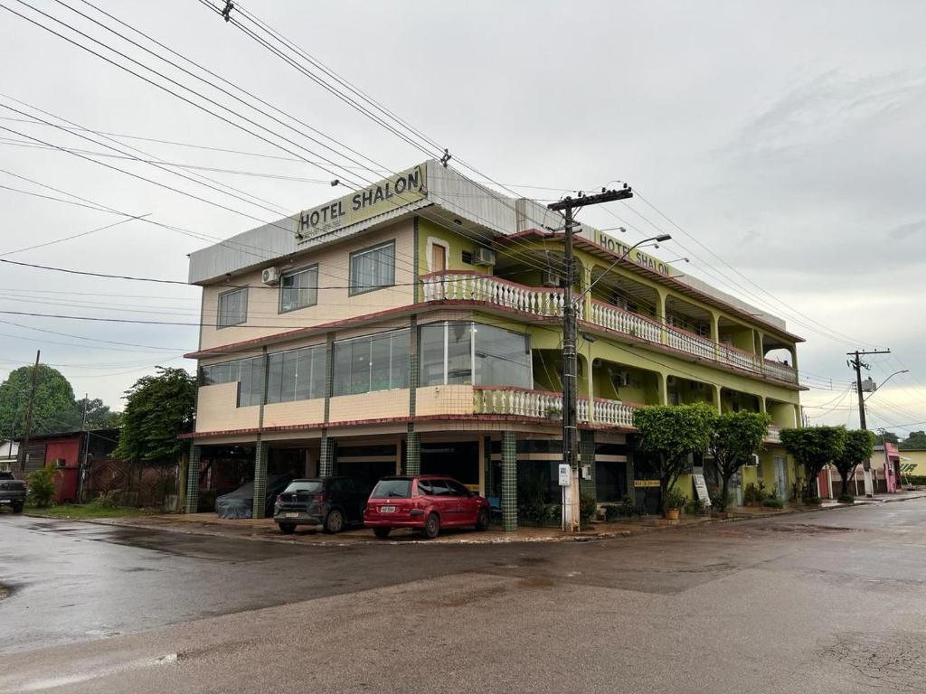 un bâtiment avec une voiture garée devant lui dans l'établissement Hotel Shalon, à Rio Branco