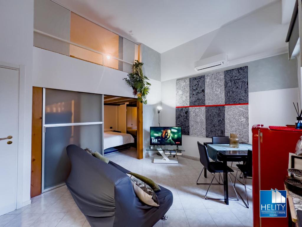ein Wohnzimmer mit einem Sofa und einem Esszimmer in der Unterkunft [S.Orsola] Industrial Design Suite* * * * * in Bologna