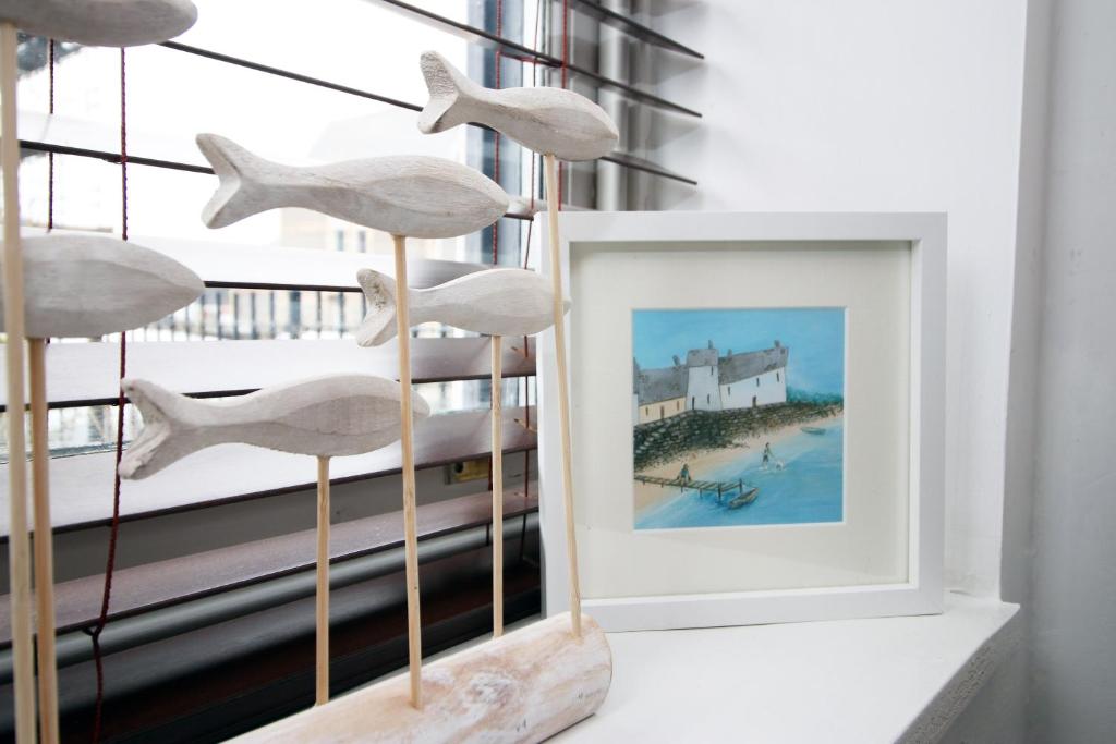 a picture frame on a shelf next to a window at Seaside town apartment 10 mins from Cardiff! in Cardiff