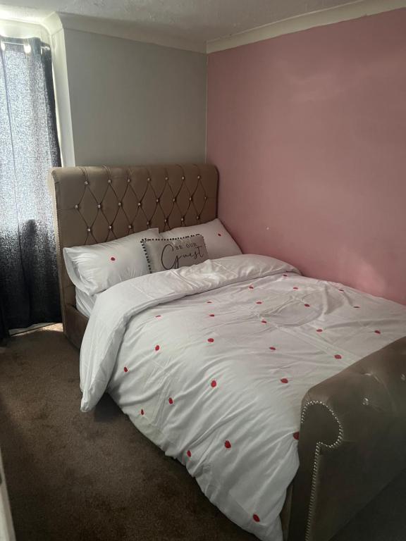 a bedroom with a white bed with red polka dots on it at Private Room in Basildon in Vange