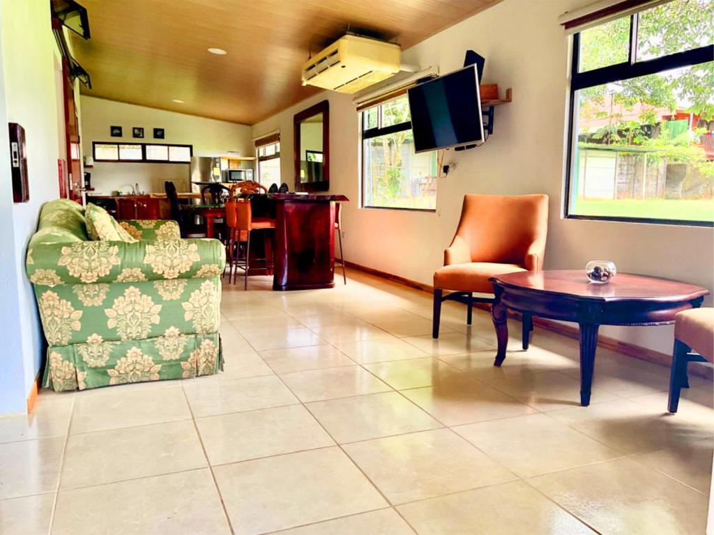 sala de estar con mesa, sillas y TV en Tropical Housing by El Rodeo - Puerto Jimenez Centro, en Puerto Jiménez