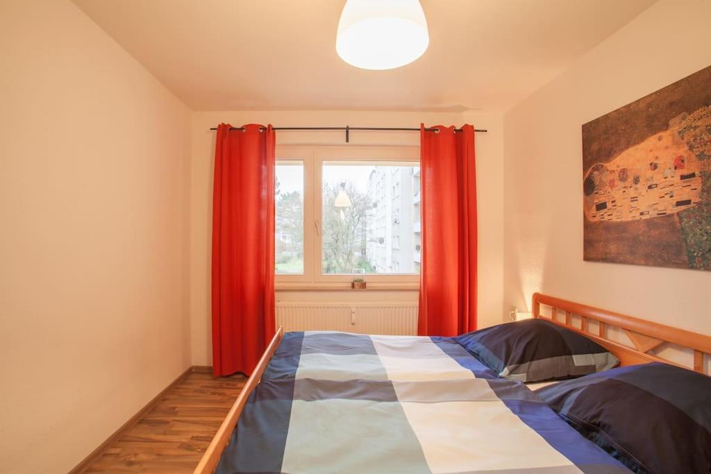 1 dormitorio con 1 cama con cortinas rojas y ventana en Schöne 2-Zimmerwohnung in Hannover-List, en Hannover