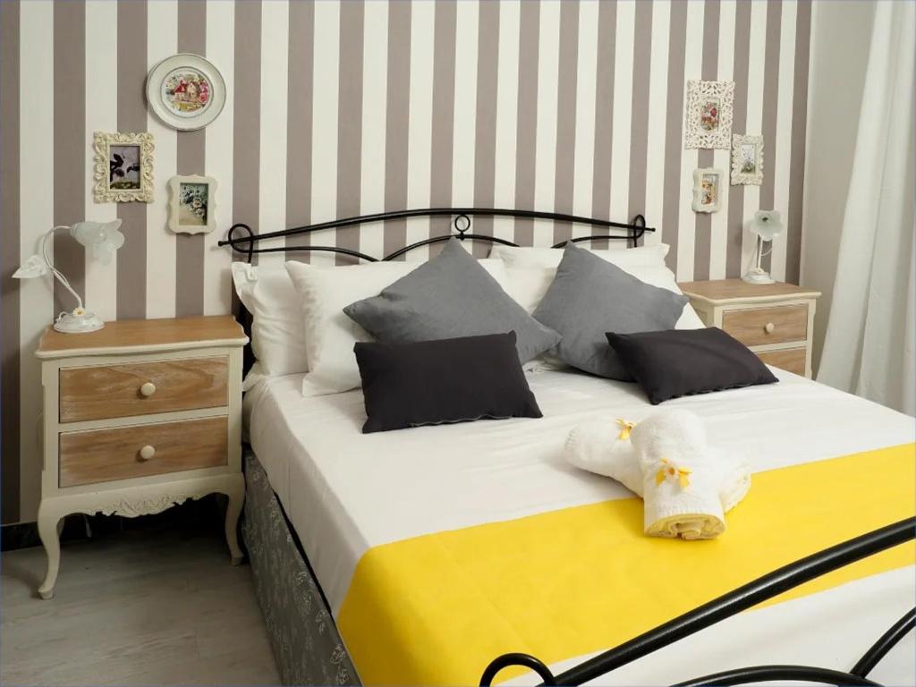 una camera da letto con un grande letto con cuscini bianchi e neri di Regina Margherita Casa Vacanza a Civitavecchia