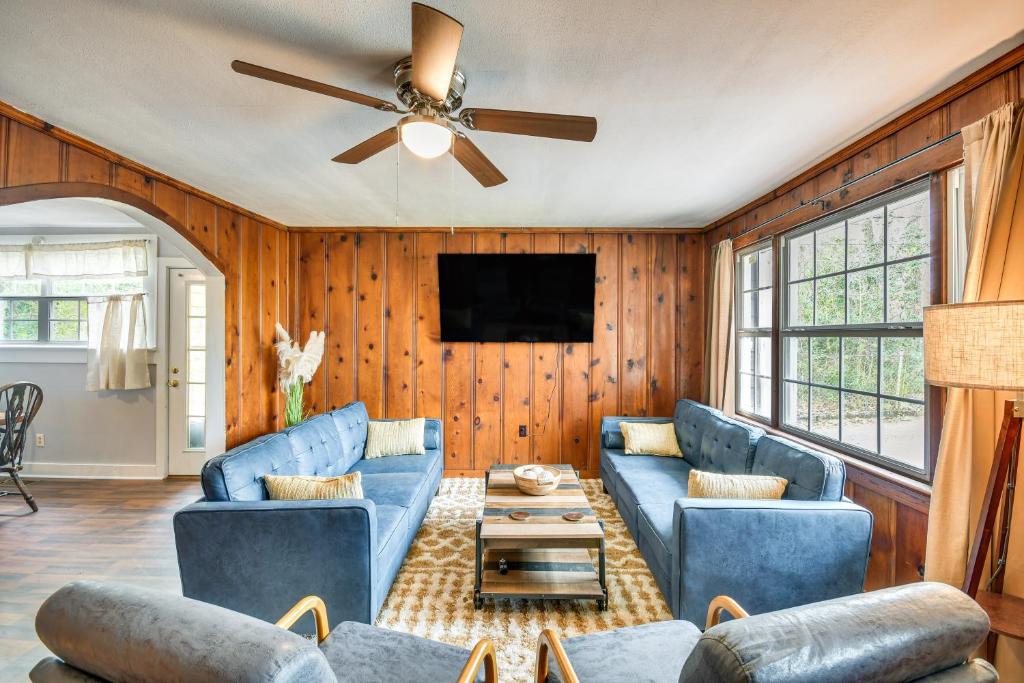 - un salon avec des canapés bleus et un ventilateur de plafond dans l'établissement Peaceful Tallassee Cottage on 2 Acres!, à Tallassee