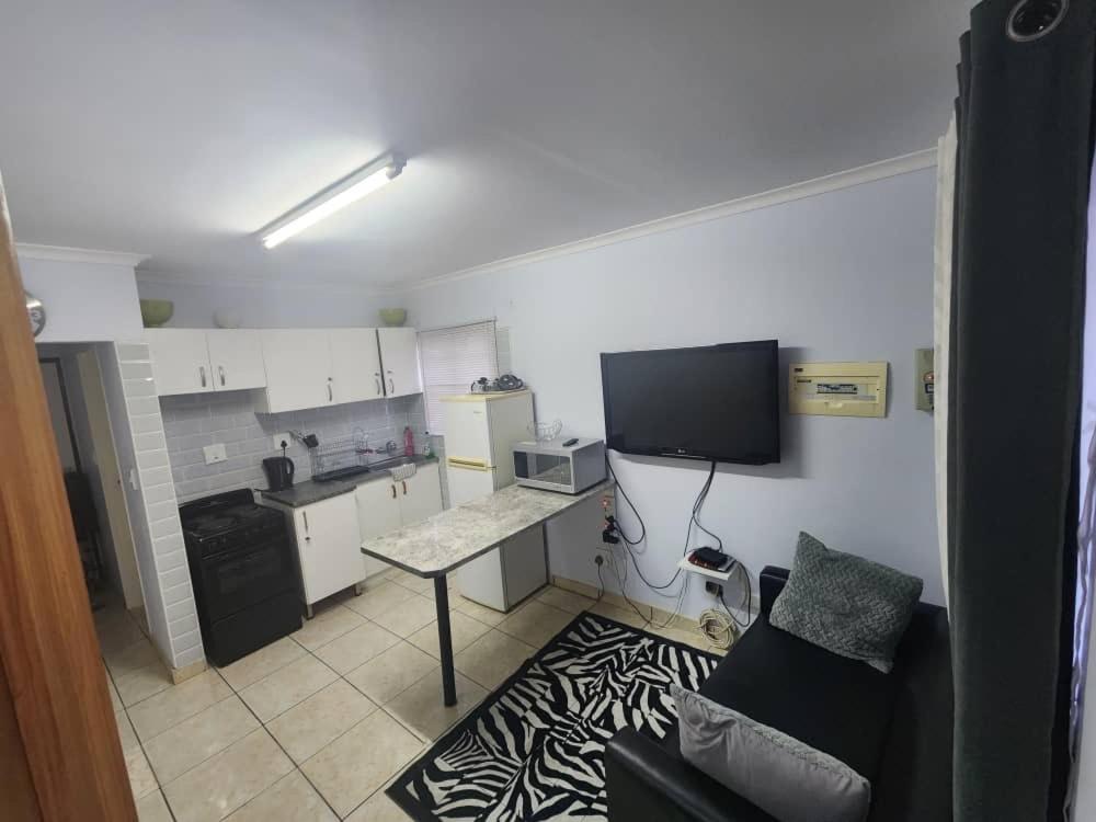 a small kitchen with a table and a tv on the wall at Elina Self catering in Ongwediva