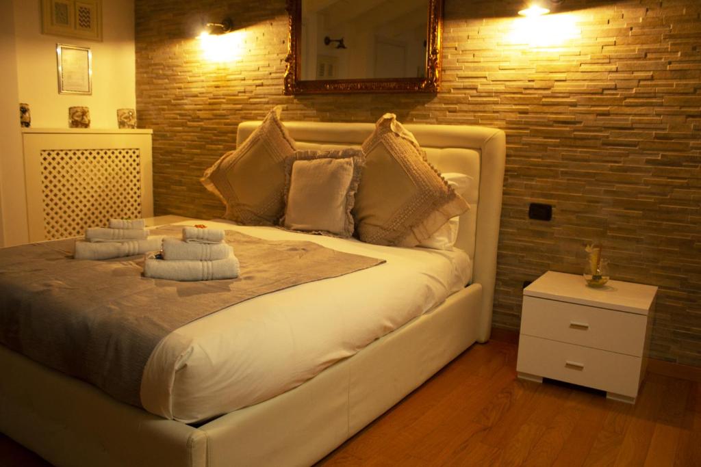 een groot wit bed in een kamer met een bakstenen muur bij BB TORTONA in Milaan