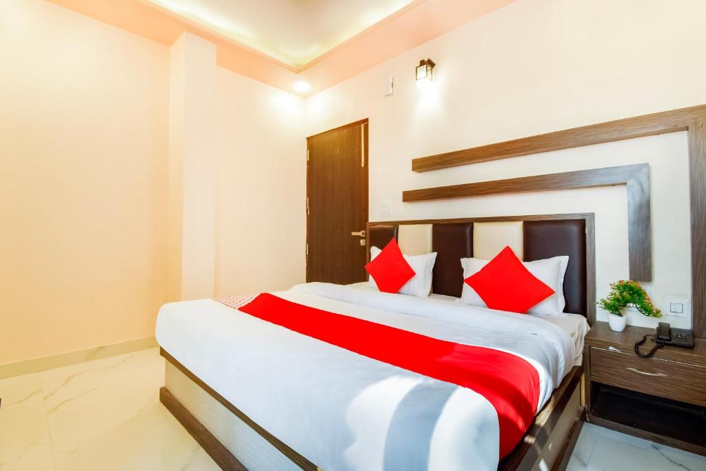 een slaapkamer met een groot bed met rode kussens bij OYO Flagship Hotel Classico Inn in Jaipur
