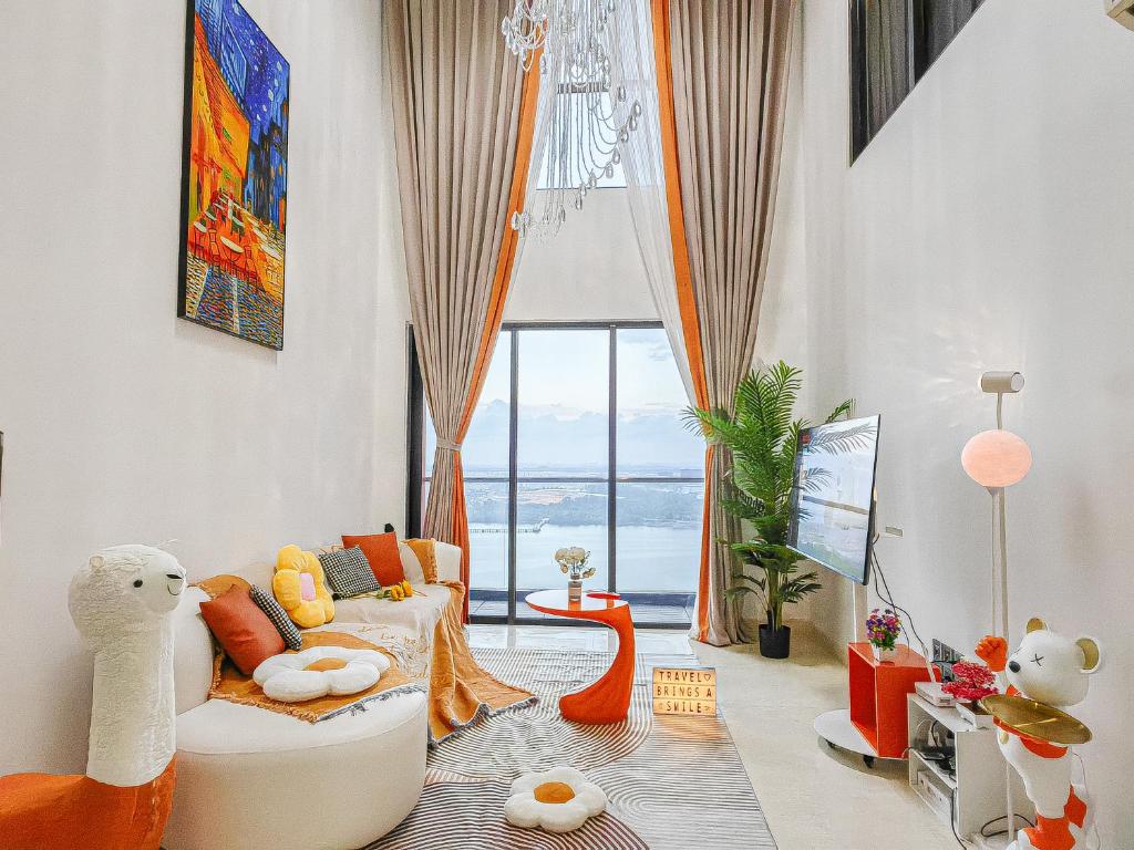 - un salon avec un canapé blanc et une grande fenêtre dans l'établissement Jacuzzi,Loft,Highest Floor,SG city View,10min to CIQ, à Johor Bahru
