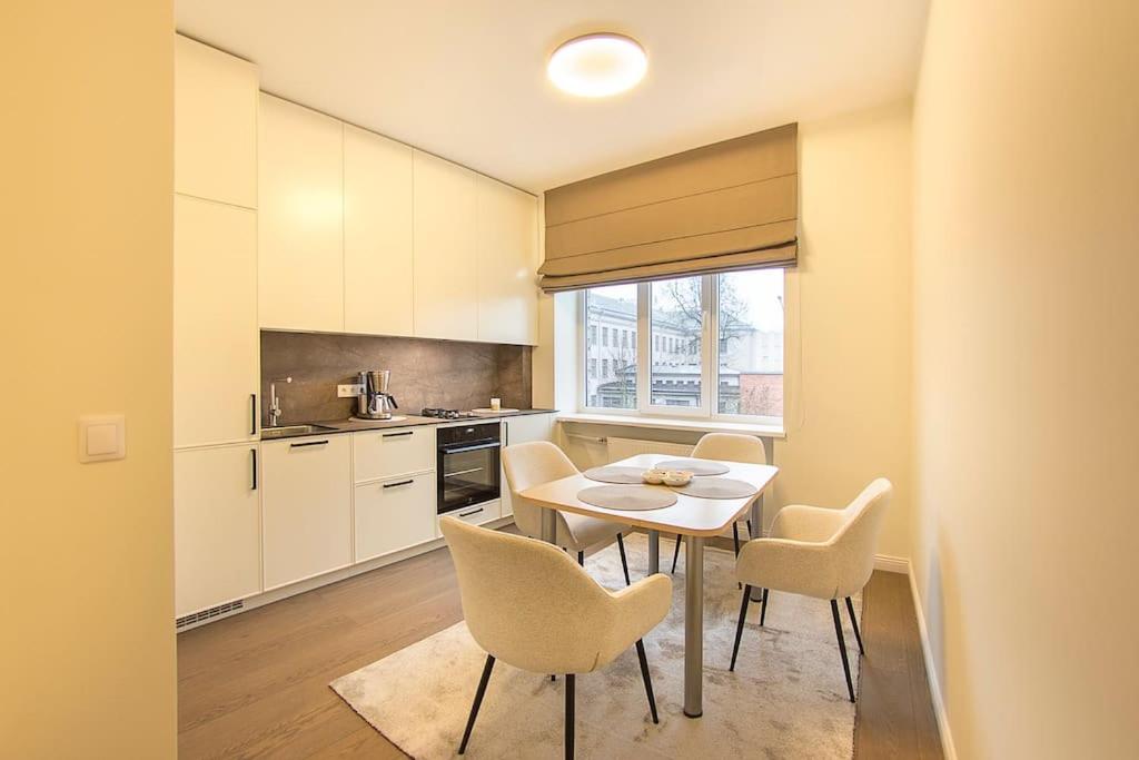 Una cocina con una mesa y sillas en una habitación. en Butas Šiaulių mieste, en Šiauliai