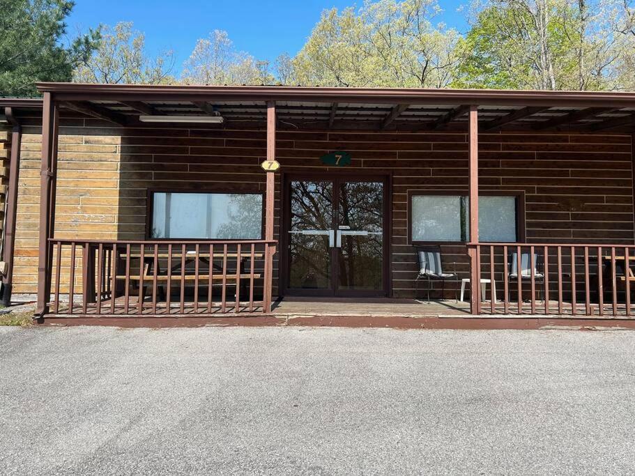 un edificio de madera con una puerta grande y un porche en Adjoining Cabin #7A at Patoka 4 Seasons Resort en Scottsburg