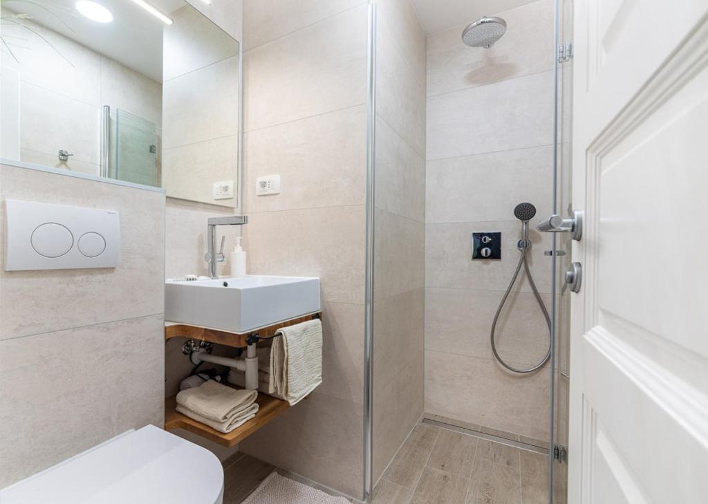 a bathroom with a shower and a toilet and a sink at Guesthouse Casa Nova in Poreč