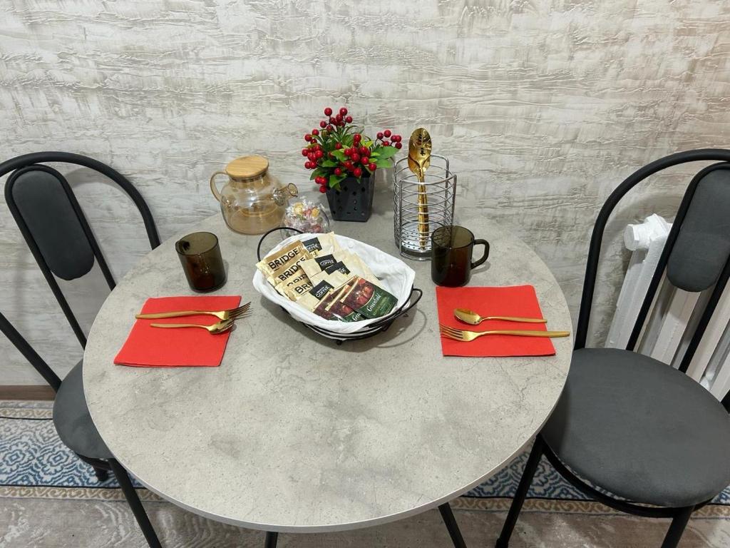 una mesa con servilletas rojas y un plato de comida en Апартаменты 2-х и 1 комнатные, en Taraz