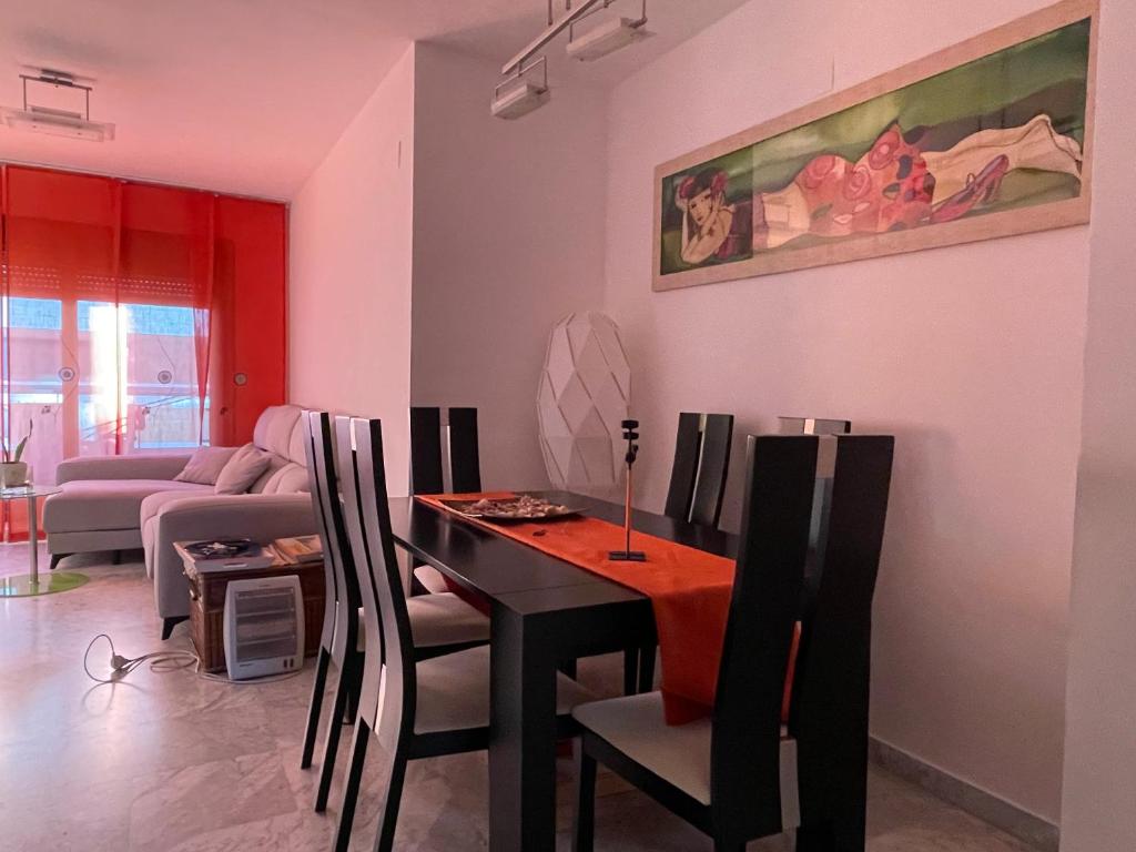 a living room with a table and chairs and a couch at Apartamento Guadalquivir - Parking Privado Opt in Seville