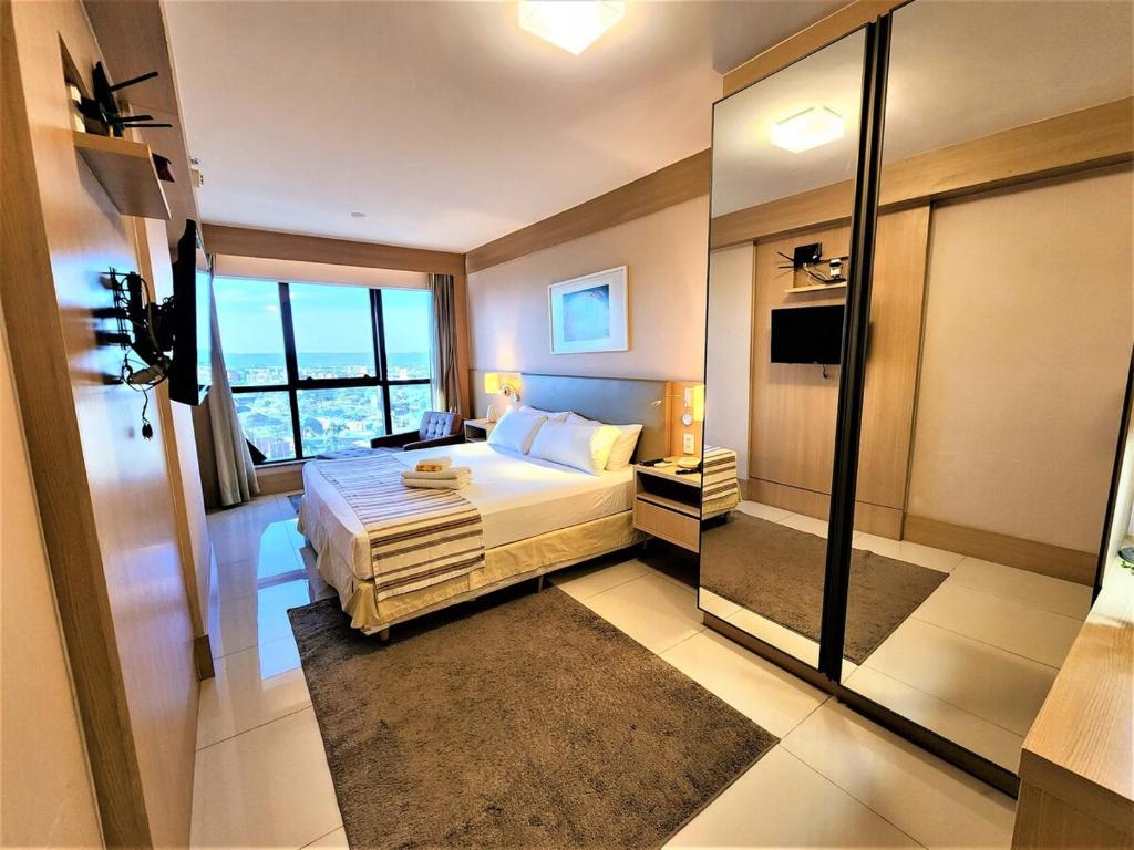 1 dormitorio con cama y ventana grande en Cullinan 1110E · Hotel Cullinan Luxury Premium quarto com vista, en Brasilia