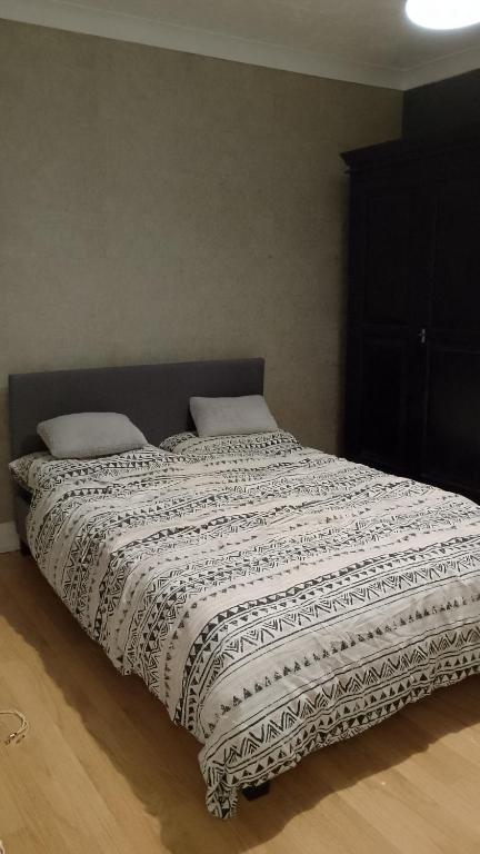 a bed with a black and white comforter on it at Twenty-six in King's Lynn