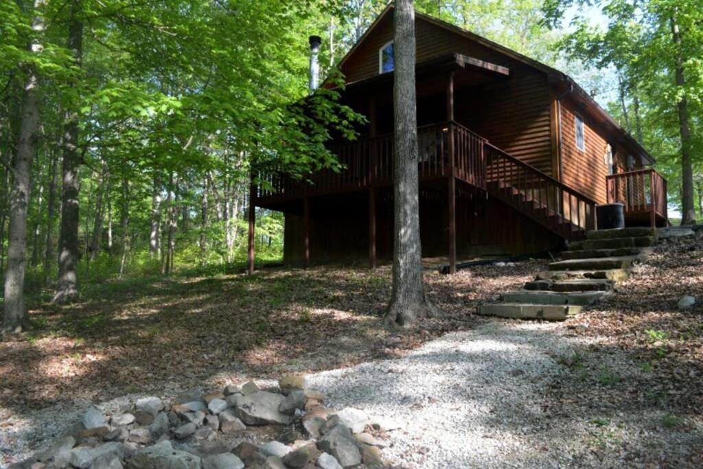 a log cabin in the woods with stairs leading to it at Deluxe Cabin #10 with Jacuzzi on Patoka Lake in Southern Indiana in Seymour
