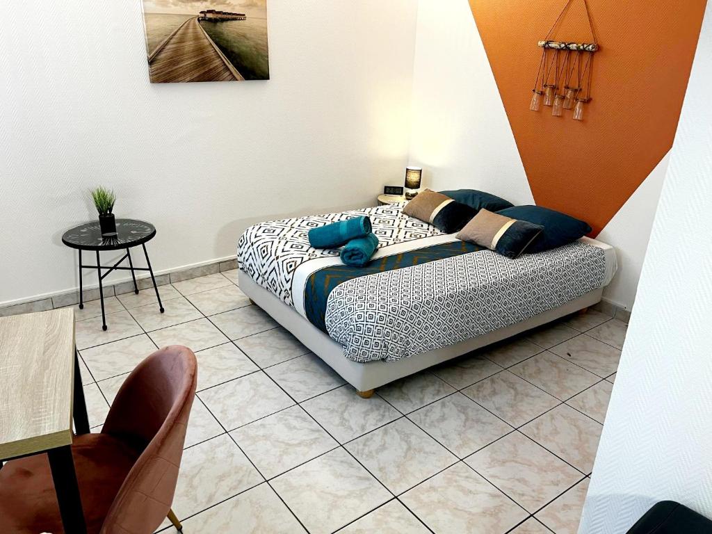 een slaapkamer met een bed, een tafel en een stoel bij Studio A au pied des Thermes de Néris-les-Bains in Néris-les-Bains