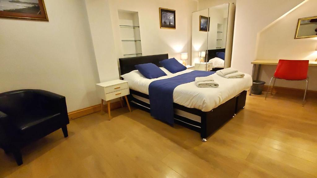 1 dormitorio con cama con sábanas azules y silla en Hastings Pad en Hastings