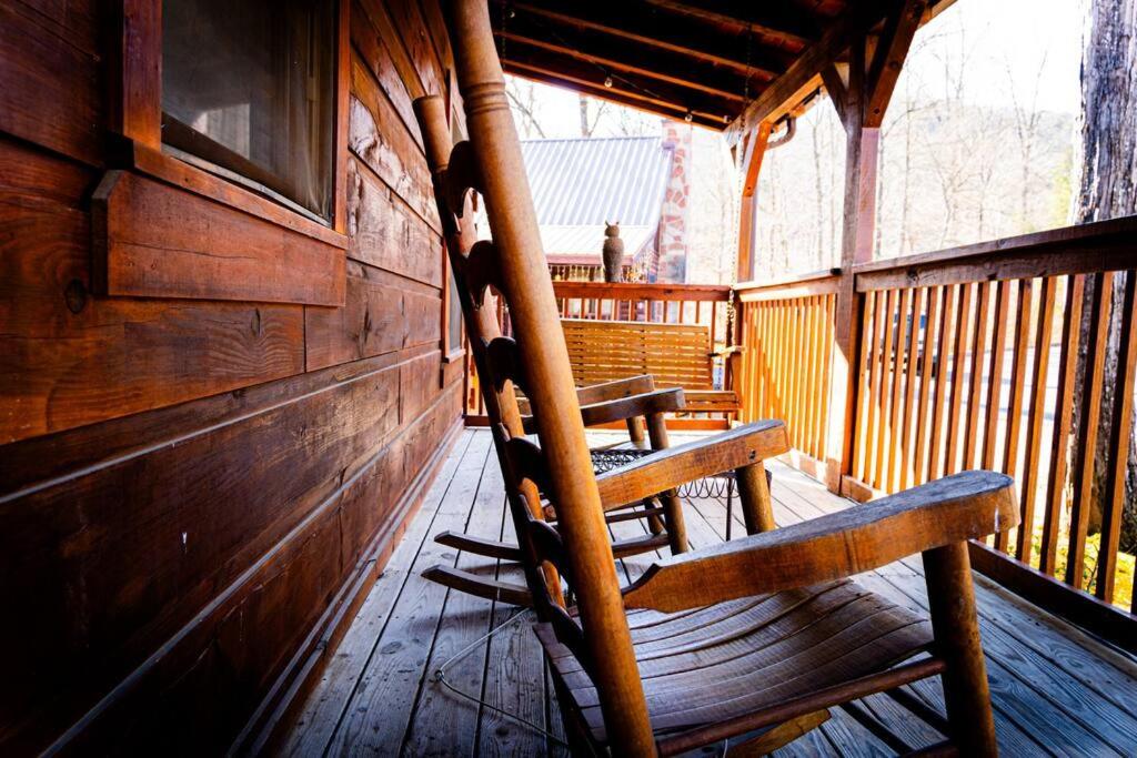 two wooden benches sitting on a porch of a cabin at Heavenly Peace in Pigeon Forge