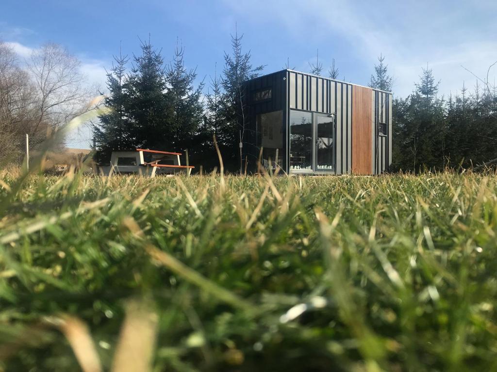 a house in the middle of a grassy field at TinyHouses & Garden in Oravská Poruba