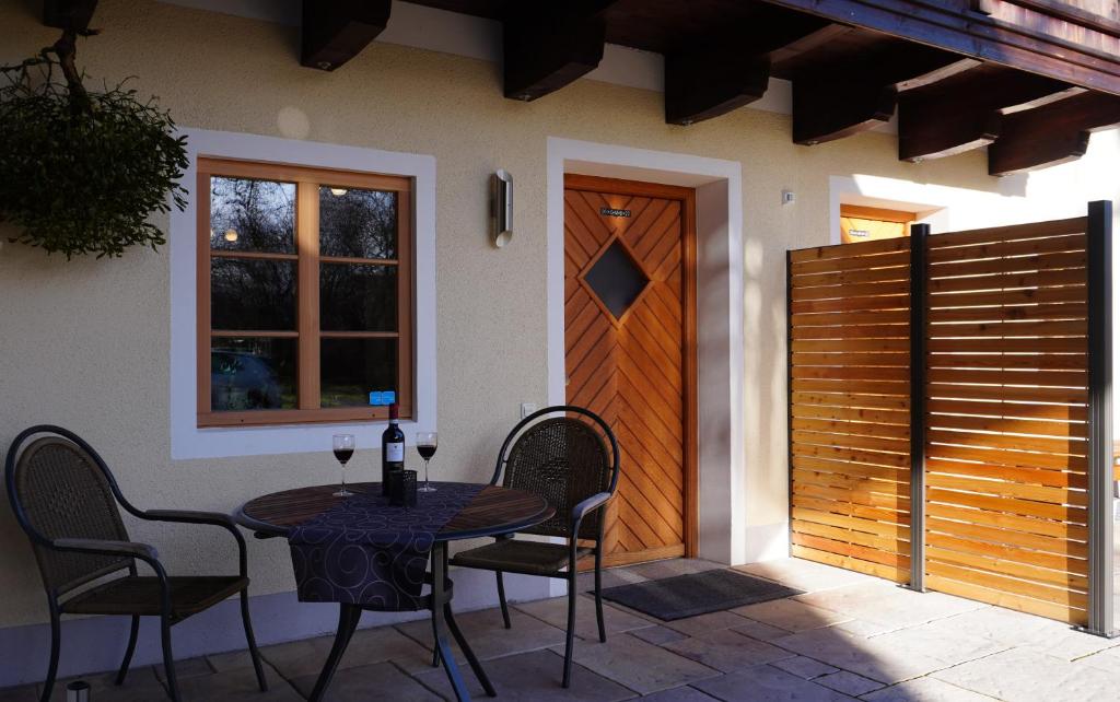 eine Terrasse mit einem Tisch und Stühlen sowie einer Holztür in der Unterkunft Ferienwohnung Am Feldbach in Bad Aibling