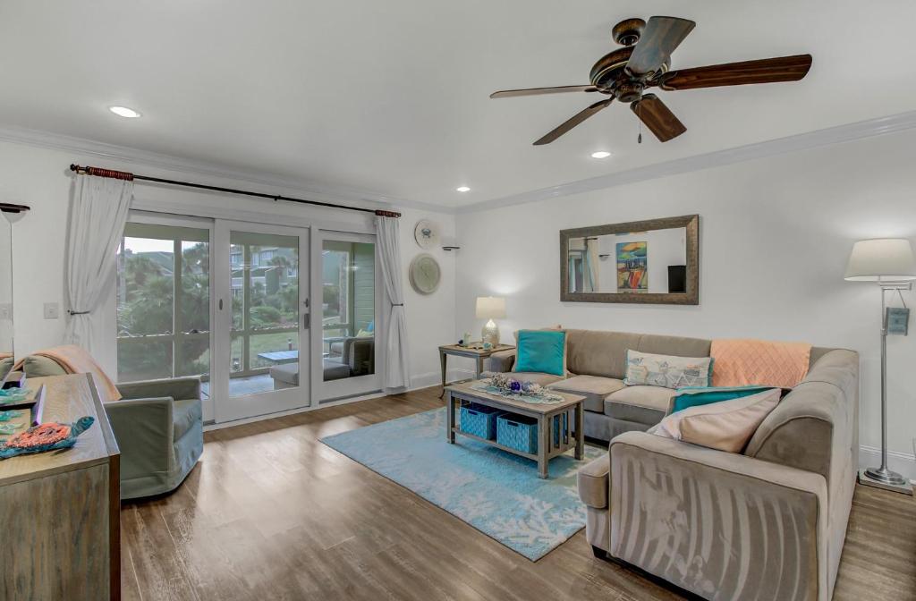 a living room with a couch and a ceiling fan at 6C Mariners AvantStay Easy Pool Beach Access in Isle of Palms