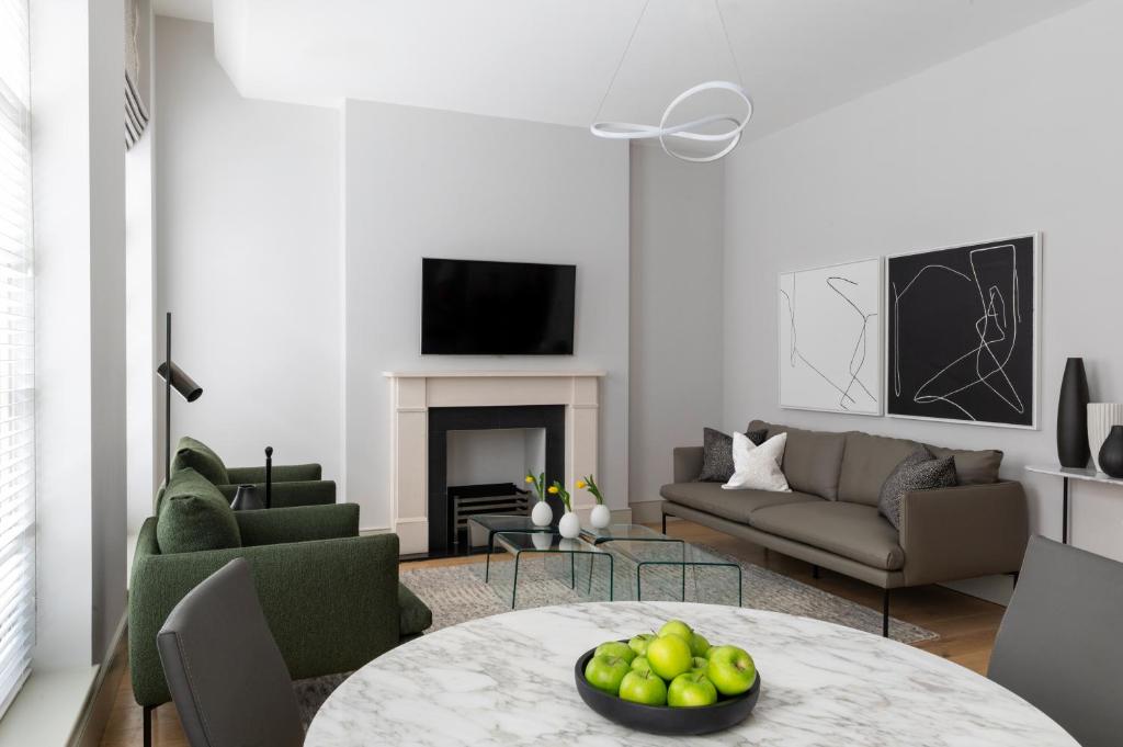 a living room with a table with a bowl of fruit at AKA Marylebone in London