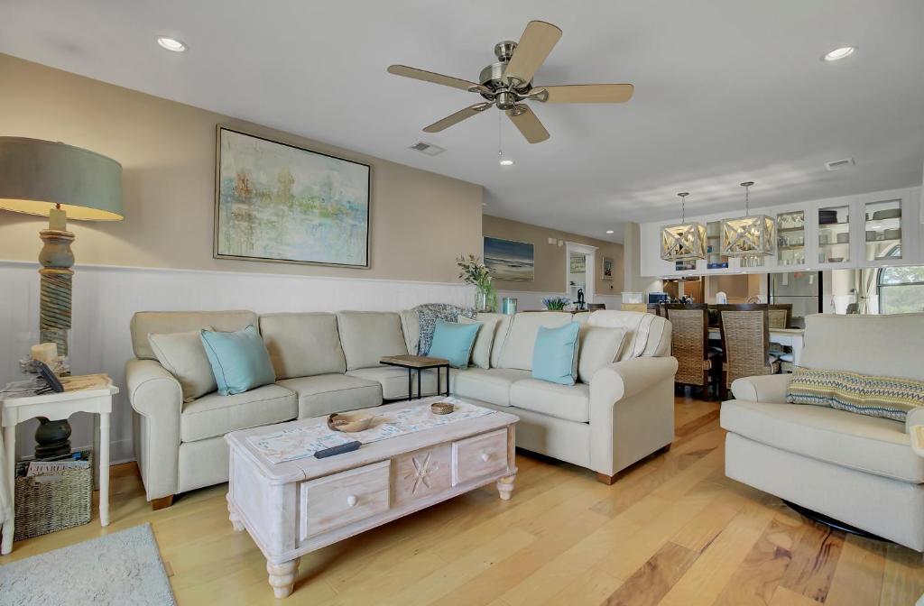 a living room with two couches and a table at 211 Seascape by AvantStay Oceanfront View Pool in Isle of Palms