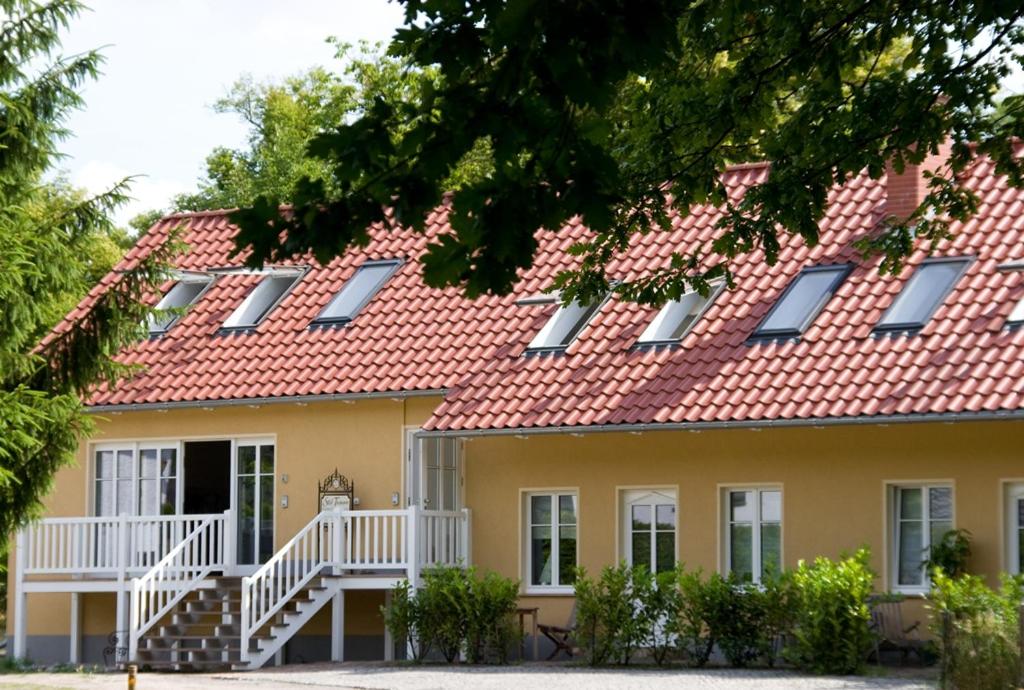 a large yellow house with a red roof at SEEBADHOF - Landhaus Kaiser in Rangsdorf