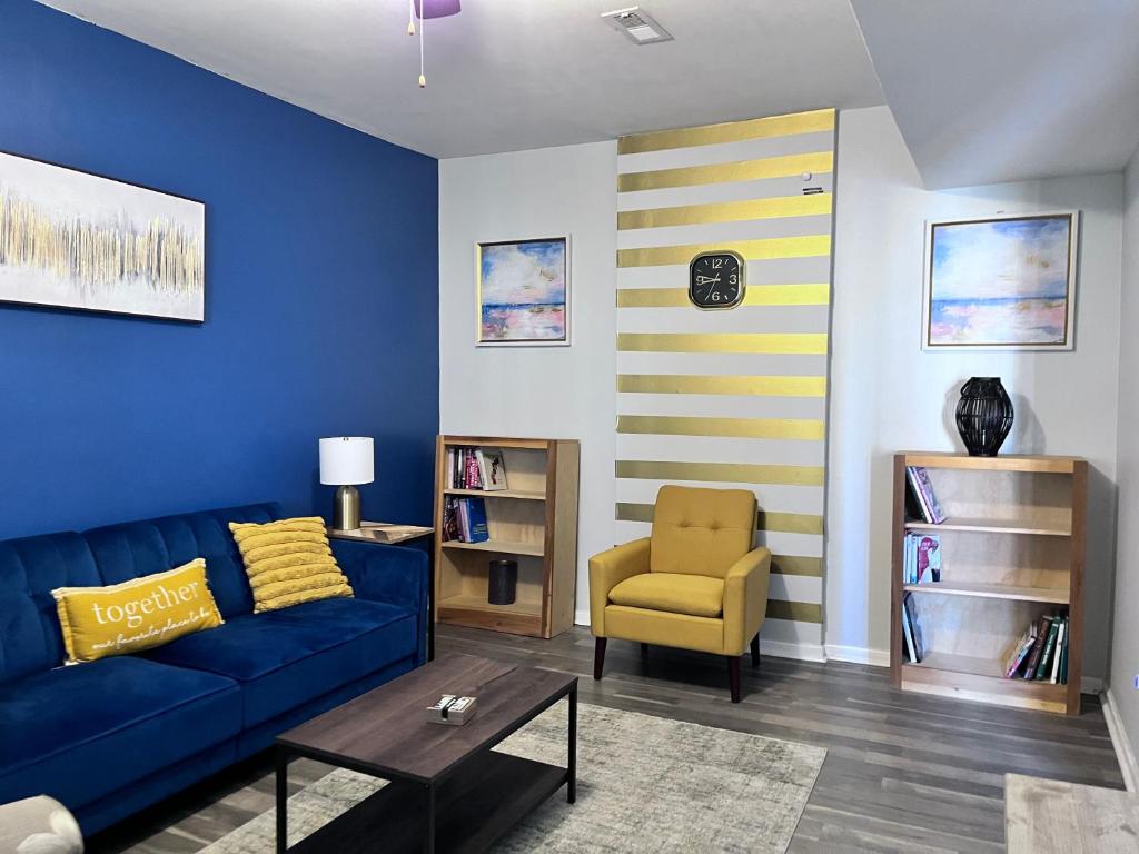 un salon avec un canapé bleu et un fauteuil jaune dans l'établissement Richmond home near downtown Rva, à Richmond