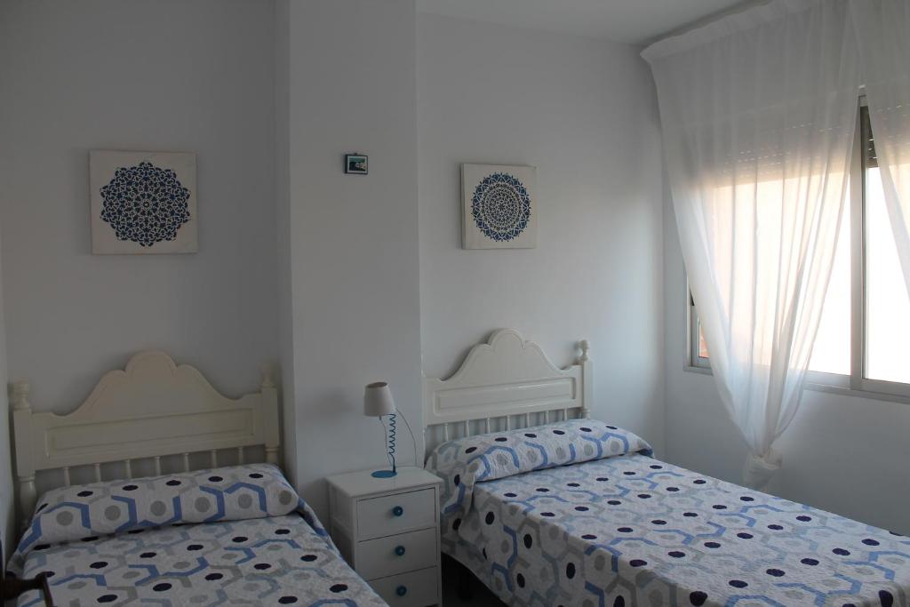 A bed or beds in a room at ApartiaBeach Apartamentos