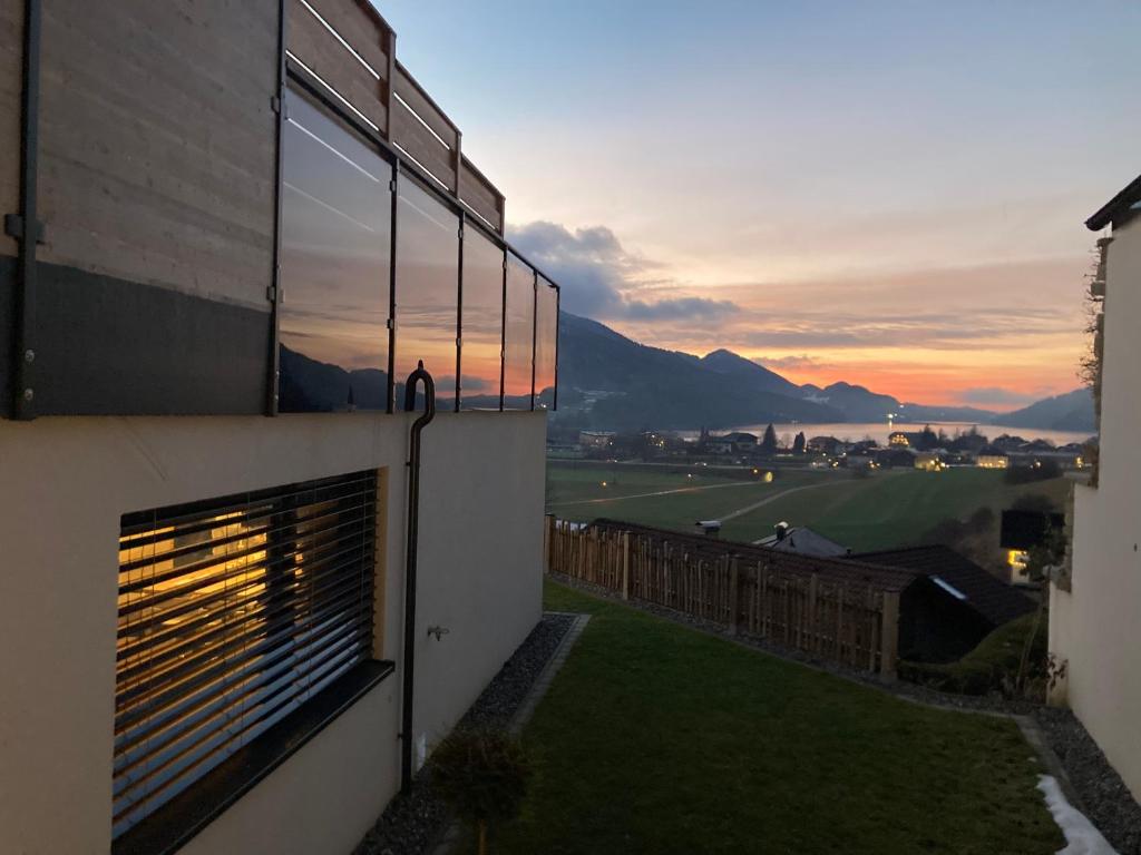 a building with a window with a sunset in the background at Pension Stöllinger mit Traumausblick in Fuschl am See