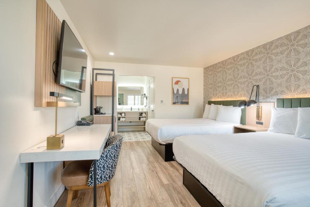 um quarto de hotel com duas camas e uma secretária em La Casa Inn em São Francisco