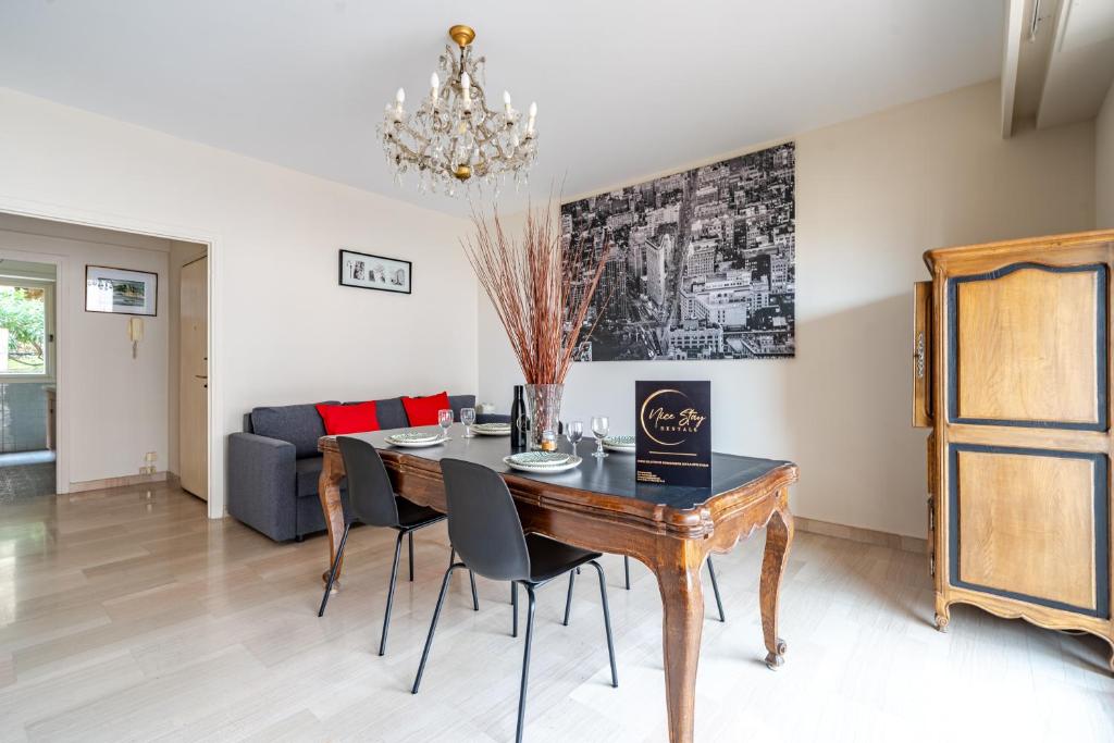 une salle à manger avec une table, des chaises et un canapé dans l'établissement Grand 3 Pièces calme - Nice - Garage, à Nice
