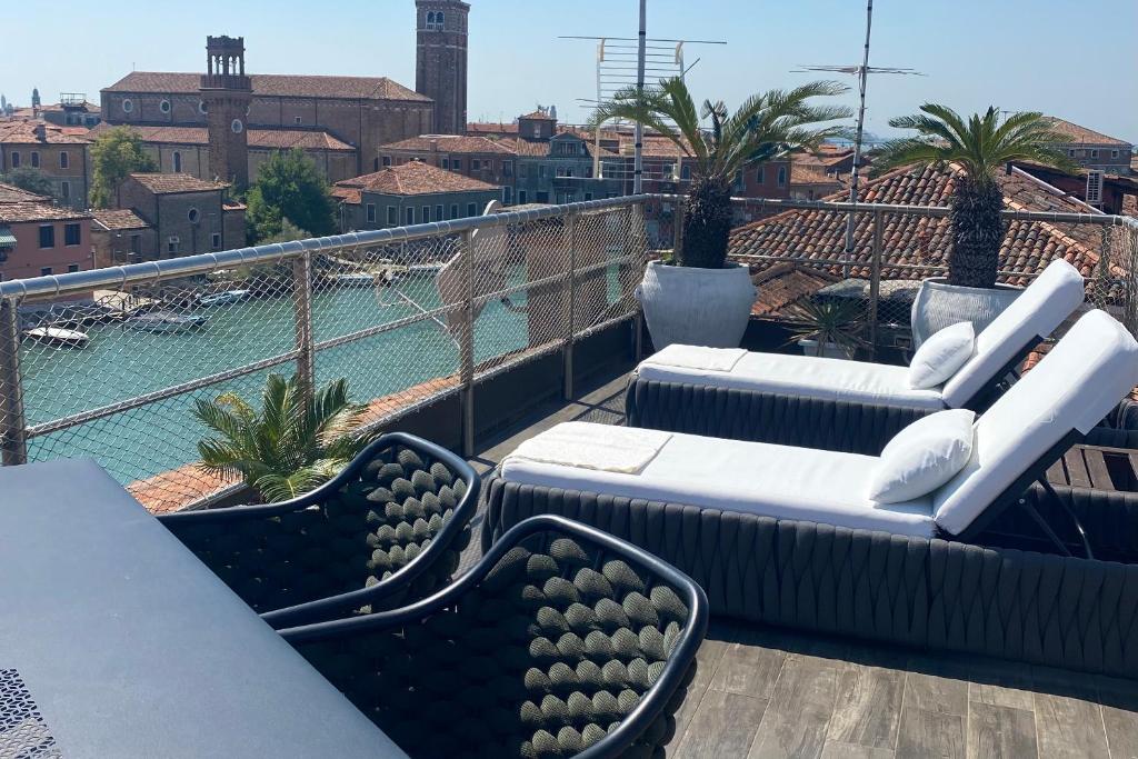 uma varanda com sofás e vista para a piscina em MURANO Suites BOUTIQUE Apartments em Murano
