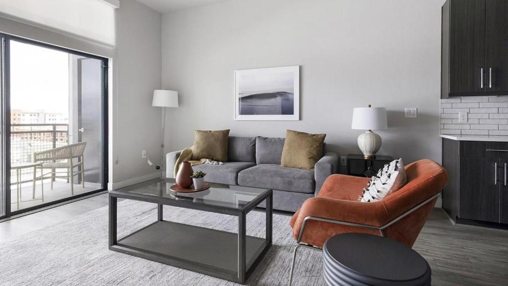 Landing Modern Apartment with Amazing Amenities (ID1802X92) في هيوستن: غرفة معيشة مع أريكة وطاولة